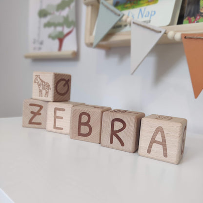 Wooden decorative blocks which spell zebra in laser engraved writing and have a picture of a zebra