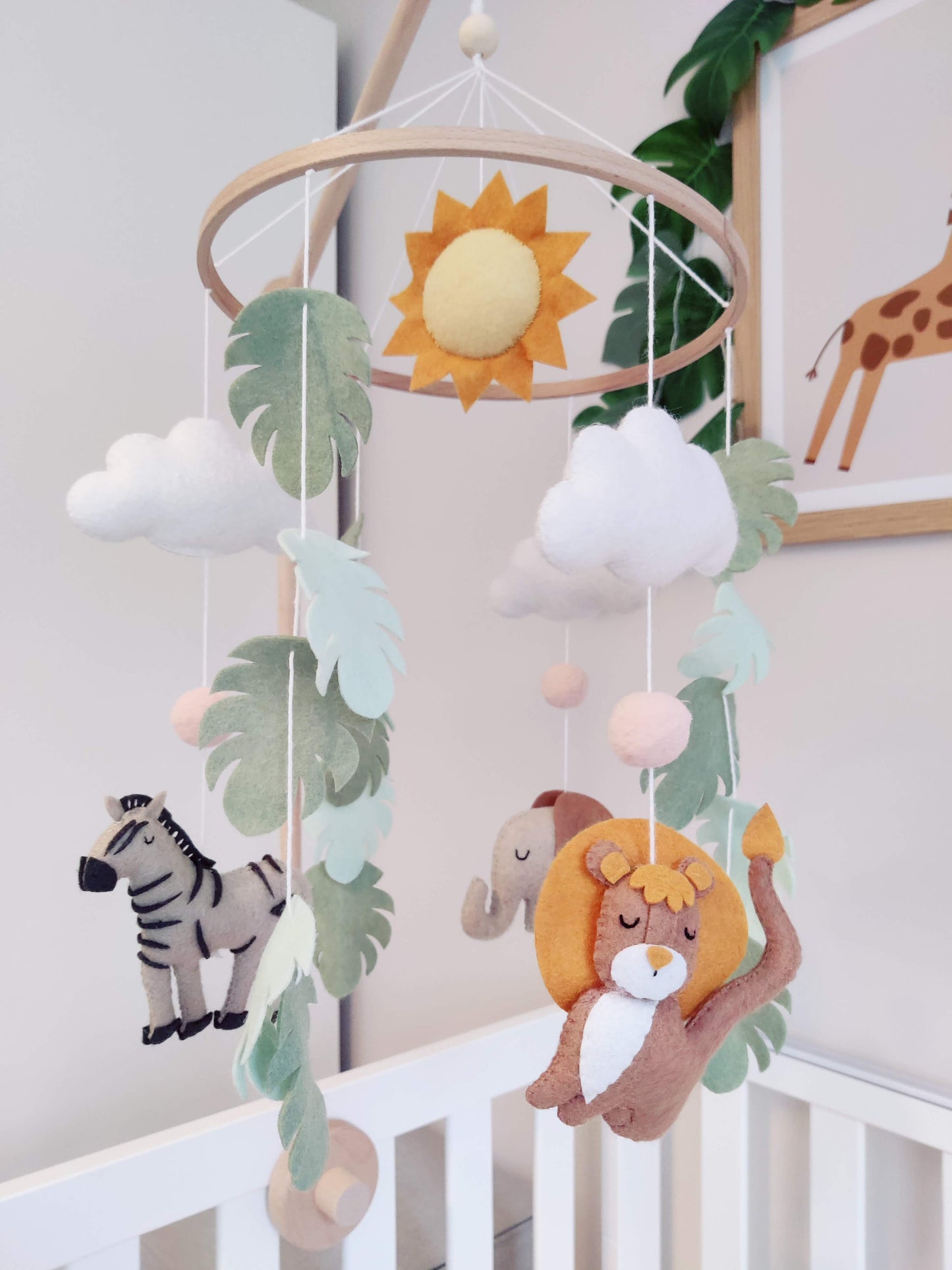 Hanging felt mobile with zebra, lion and elephant on a crib