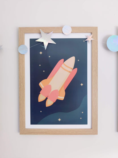 Close up photo of rocket ship artwork framed on the wall