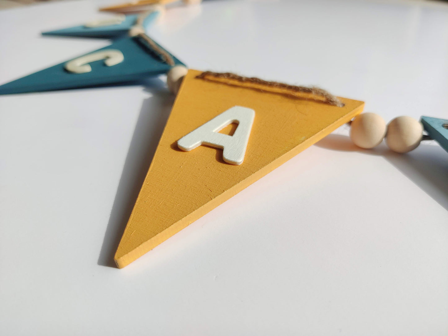Close up of yellow wooden bunting flag and the letter A