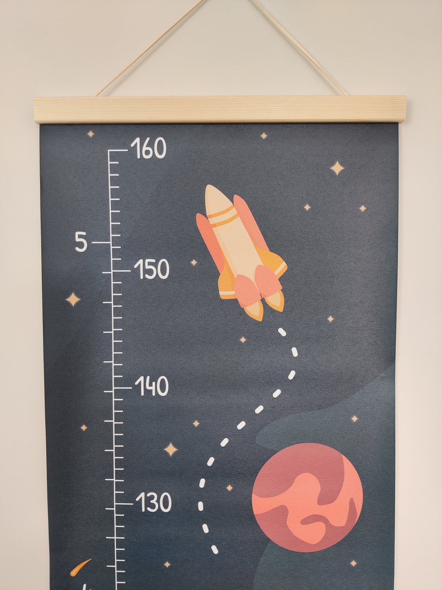 Close up of the top of a kid’s growth chart decorated with stars and planets